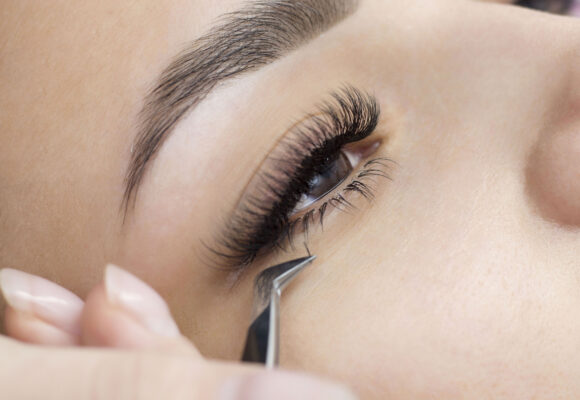 Extension of the lower eyelashes. a young woman undergoes a close-up eyelash extension procedure. Tweezers. Down below. Lash extensions.